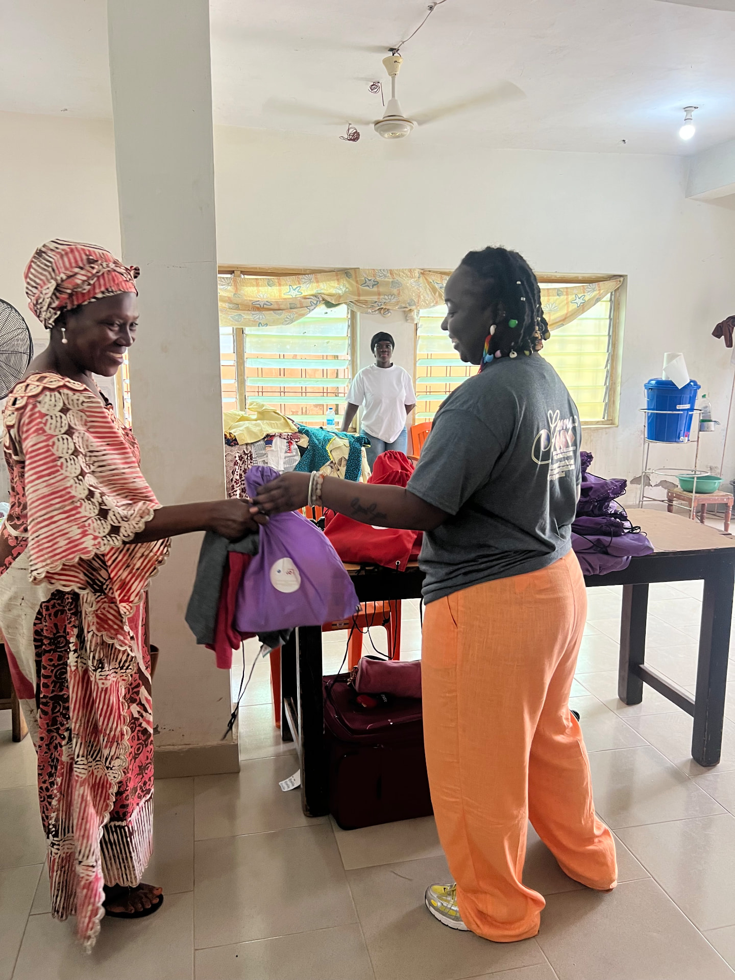 Simitri handing a care package to a community member during the Ghana medical screening outreach