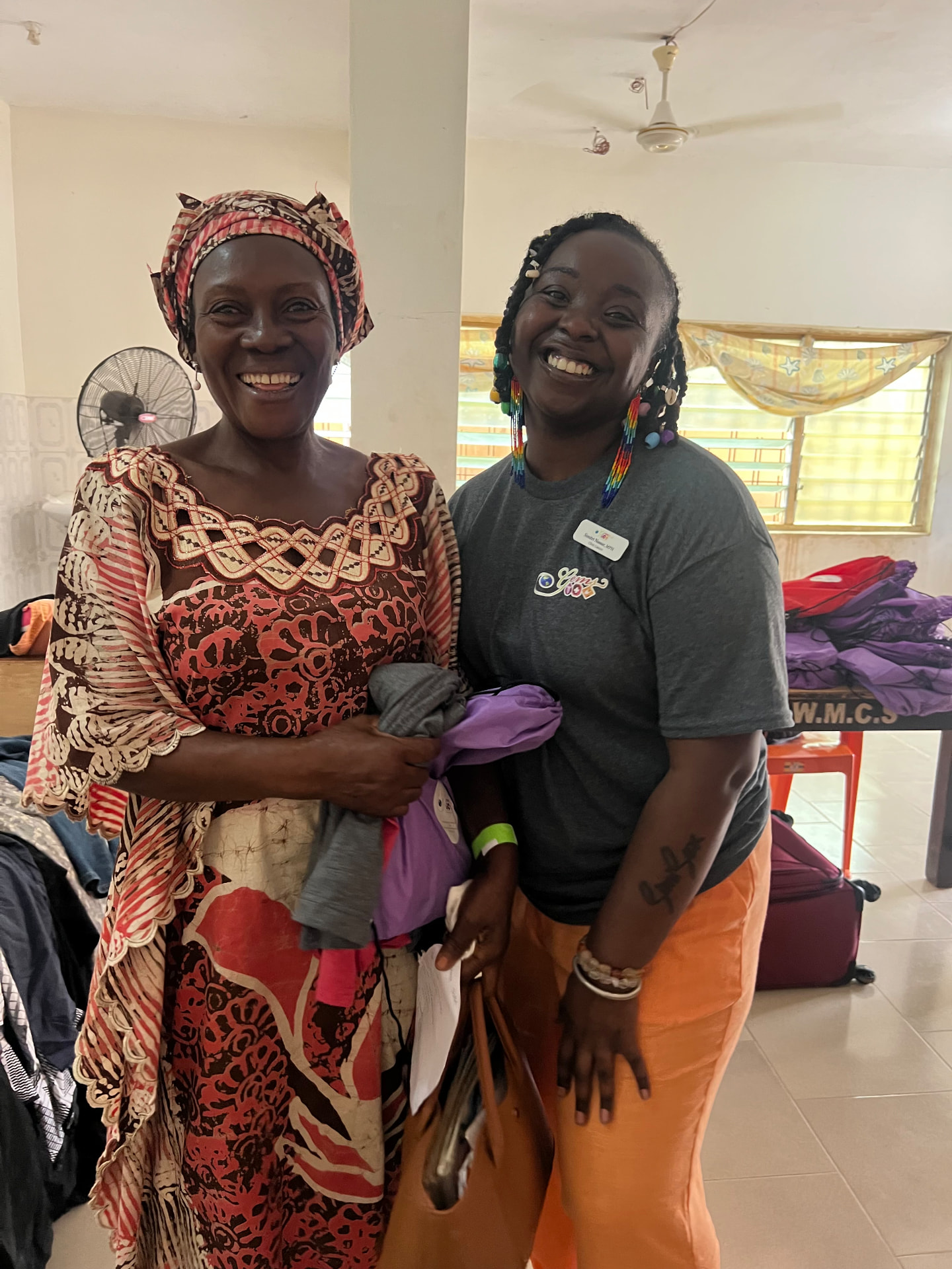 A SIM Foundation volunteer and a community member smiling together at the Ghana medical screening event